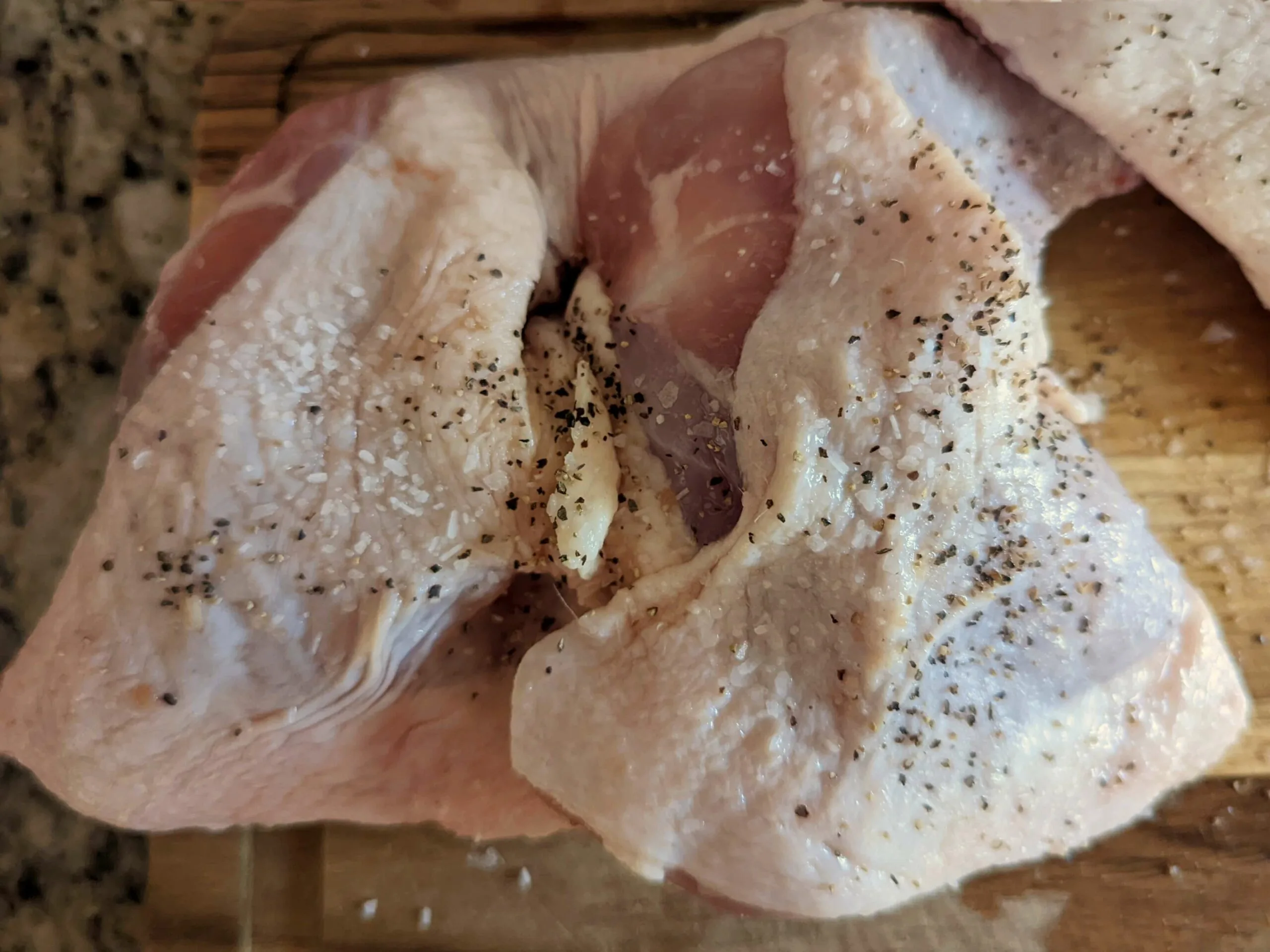 Season the chicken quarters with salt and pepper.