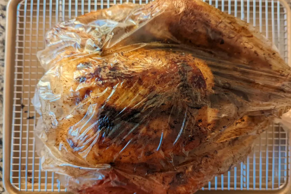 A roasted tandoori turkey resting on a wire rack.