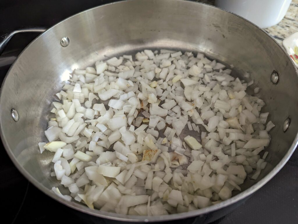 Onions and garlic sautéing in a pan.