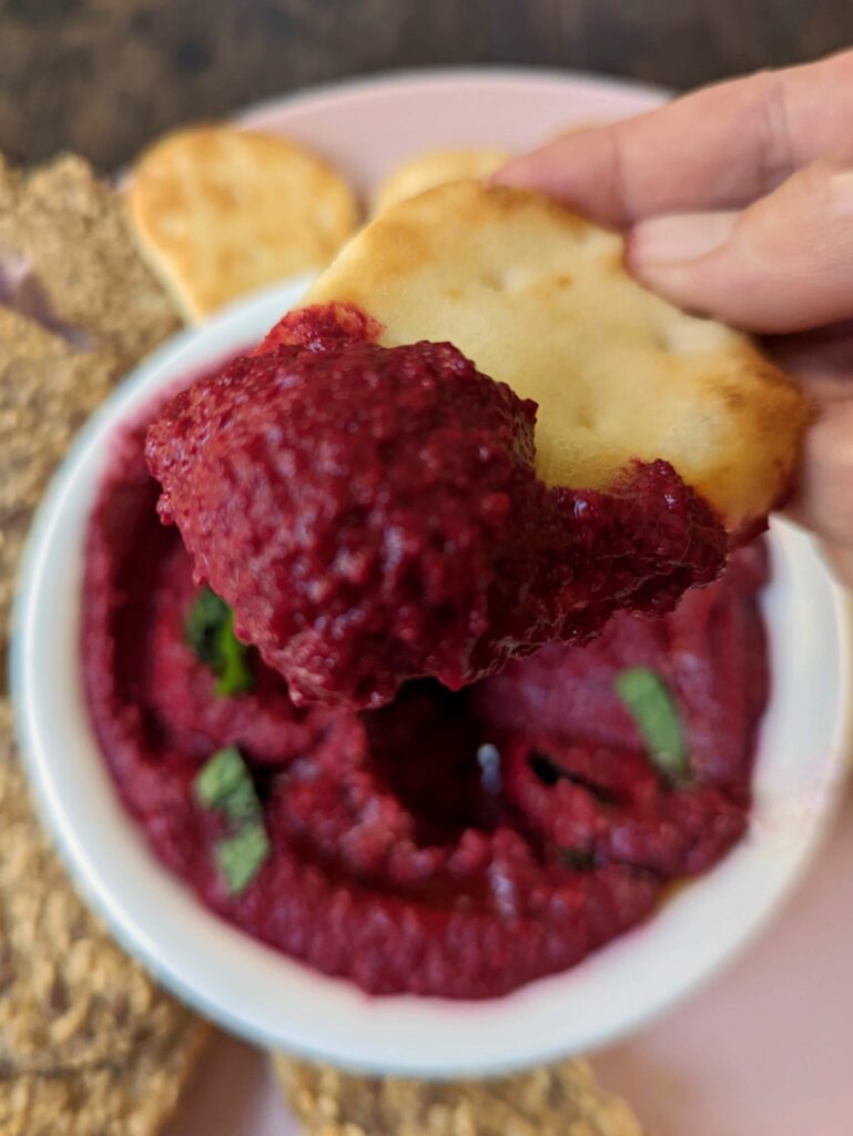 Beetroot dip scooped up with a piece of mini naan.