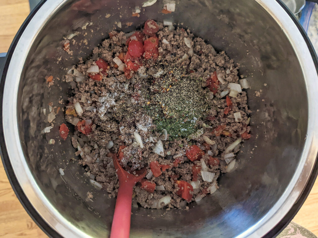Tomatoes and spices added to the Italian sausage mixture.