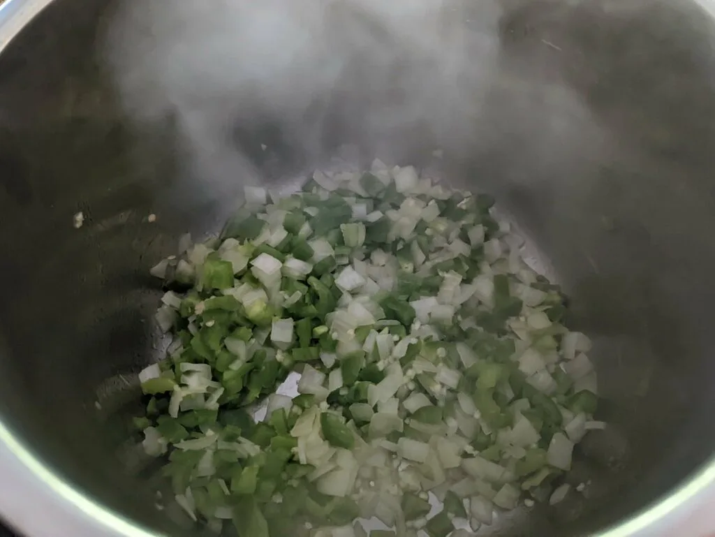 Onions and bell pepper cooking in the Instant Pot.