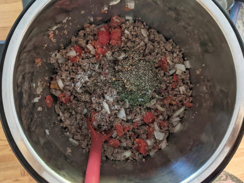 Tomatoes and spices added to the Italian sausage and onion mixture.