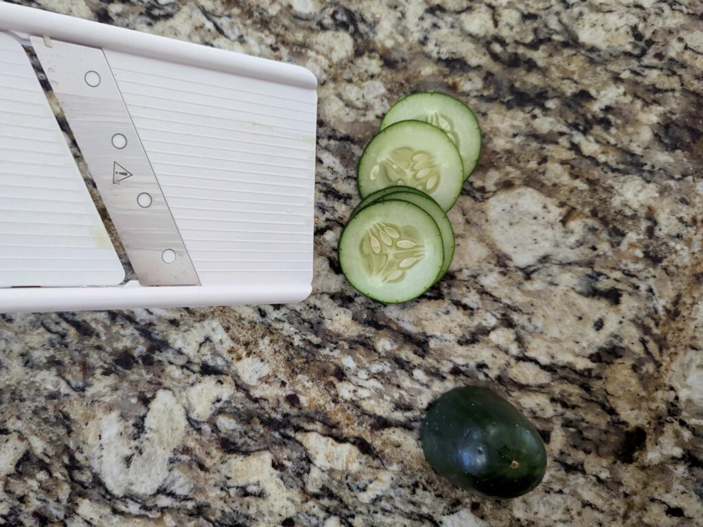 Slicing the cucumbers with a mandoline.