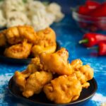Cauliflower pakoras with rice and chilies in the background.