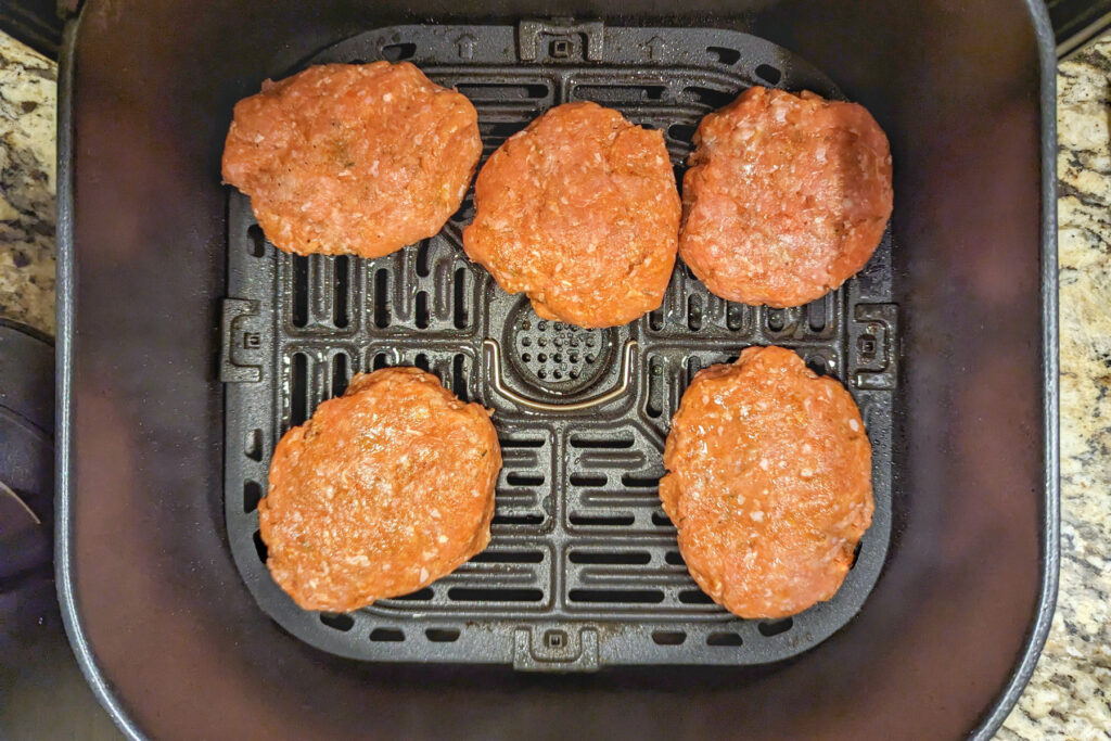 Sausage patties cooking in the air fryer.