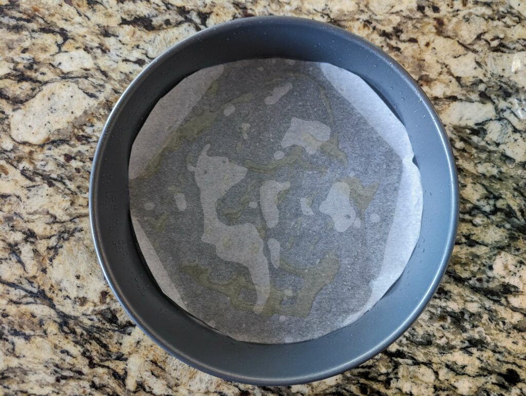 A cake pan with fitted parchment paper.