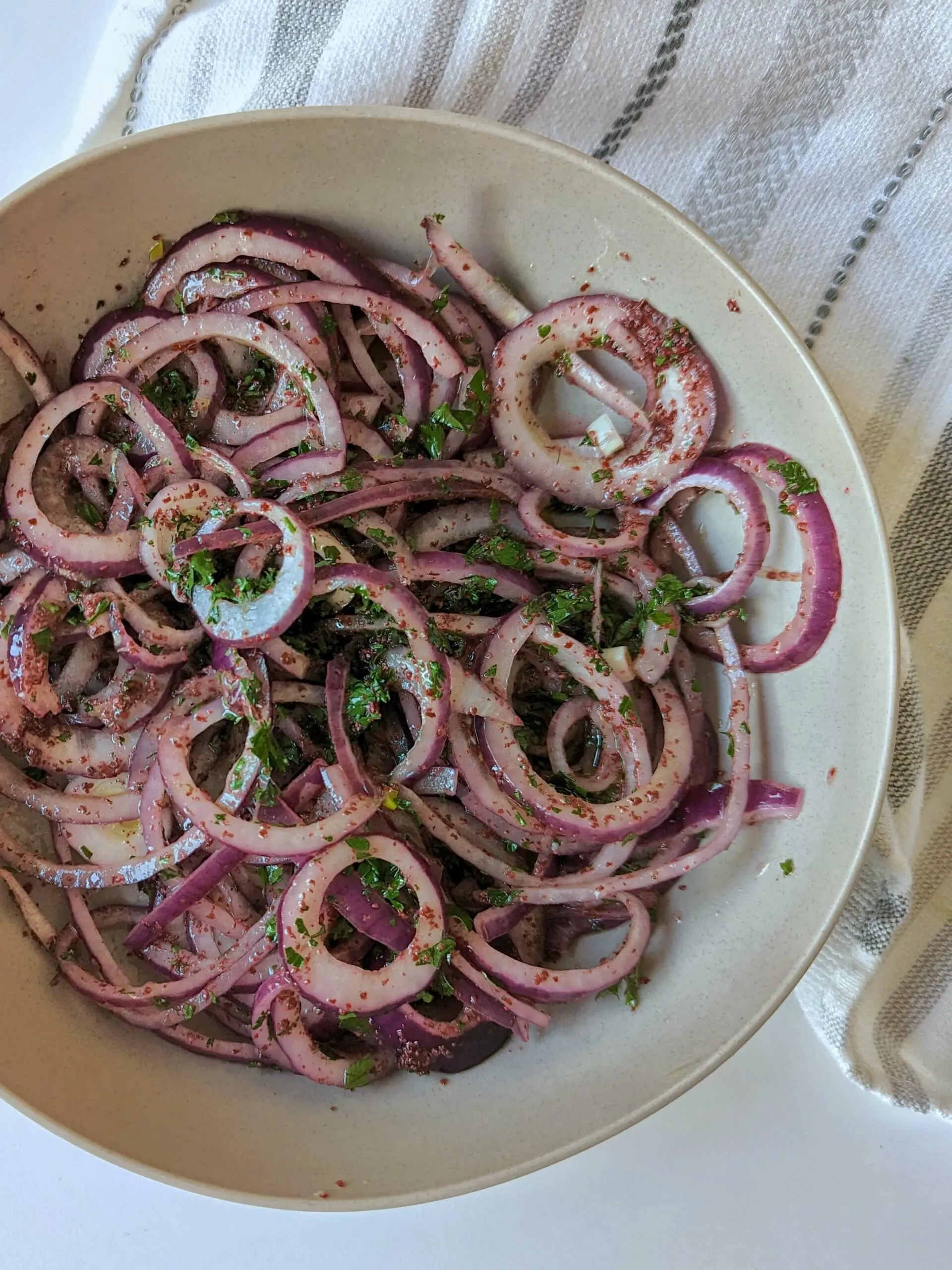 Sumac onions on a white serving bowl. 