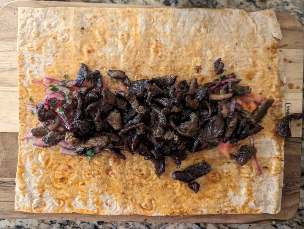 A lavash with tomatoes, sumac onions, and lamb meat.