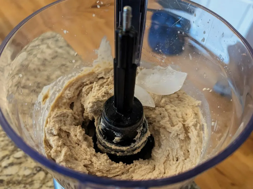 Ice added to the hummus mixture in the food processor.