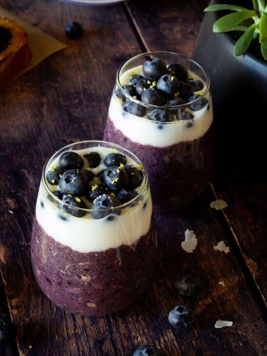 Two cups of blueberry overnight oats topped with blueberries and lemon zest. 