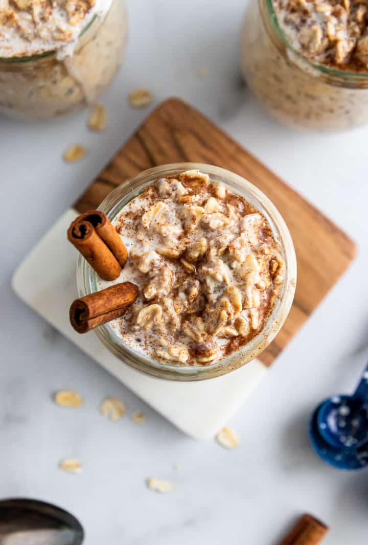 A container of overnight oats garnished with cinnamon sticks. 