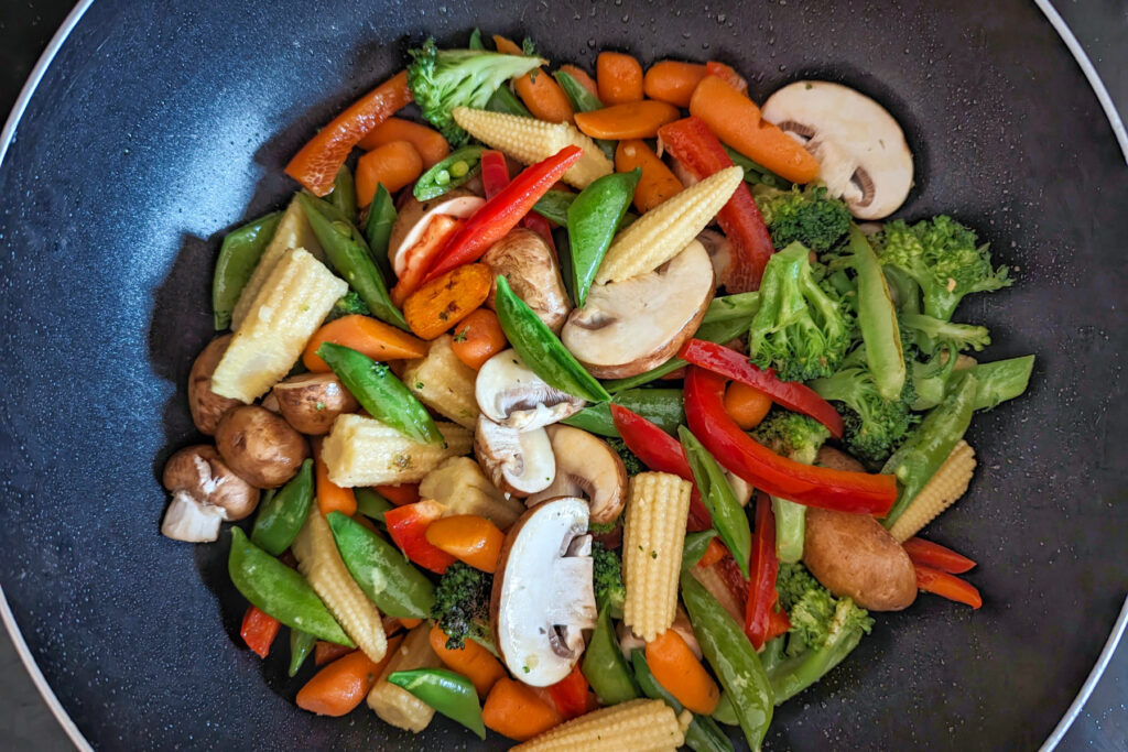 All the vegetables cooking in a wok.