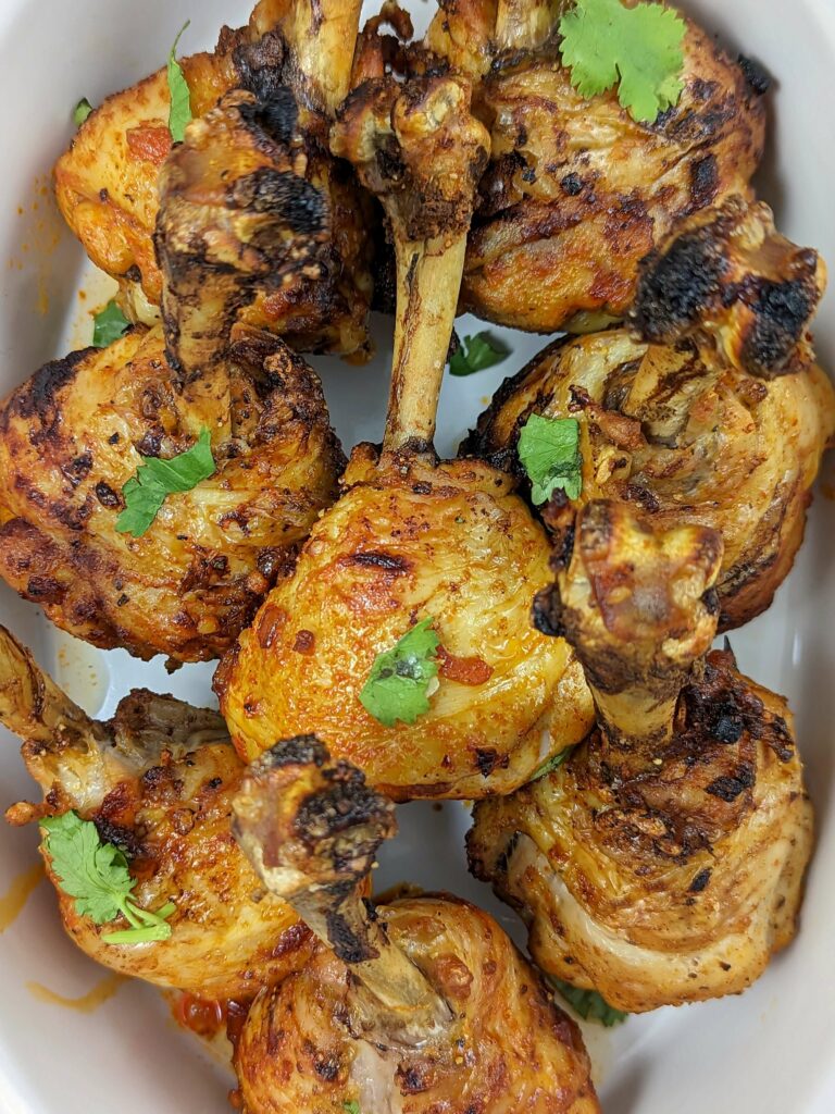 Chicken lollipops in a serving bowl and garnished with cilantro.