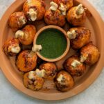 Chicken lollipops on a serving dish with cilantro chutney.