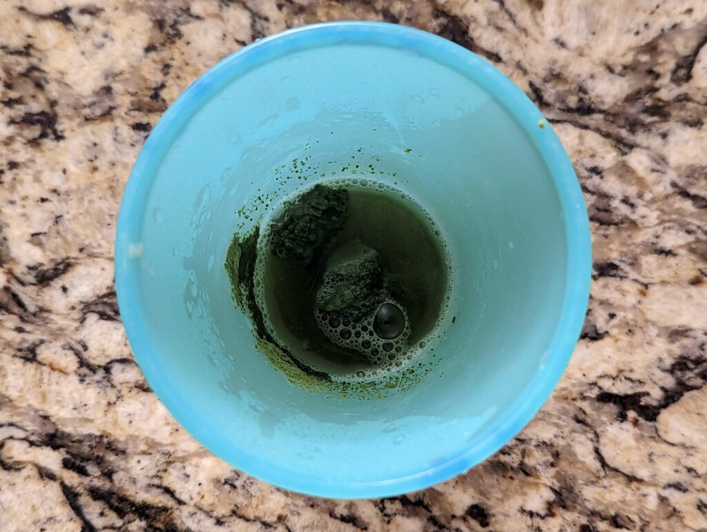 Matcha, hot water, and honey combined in a cup.
