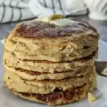 A stack of pancakes topped with butter.