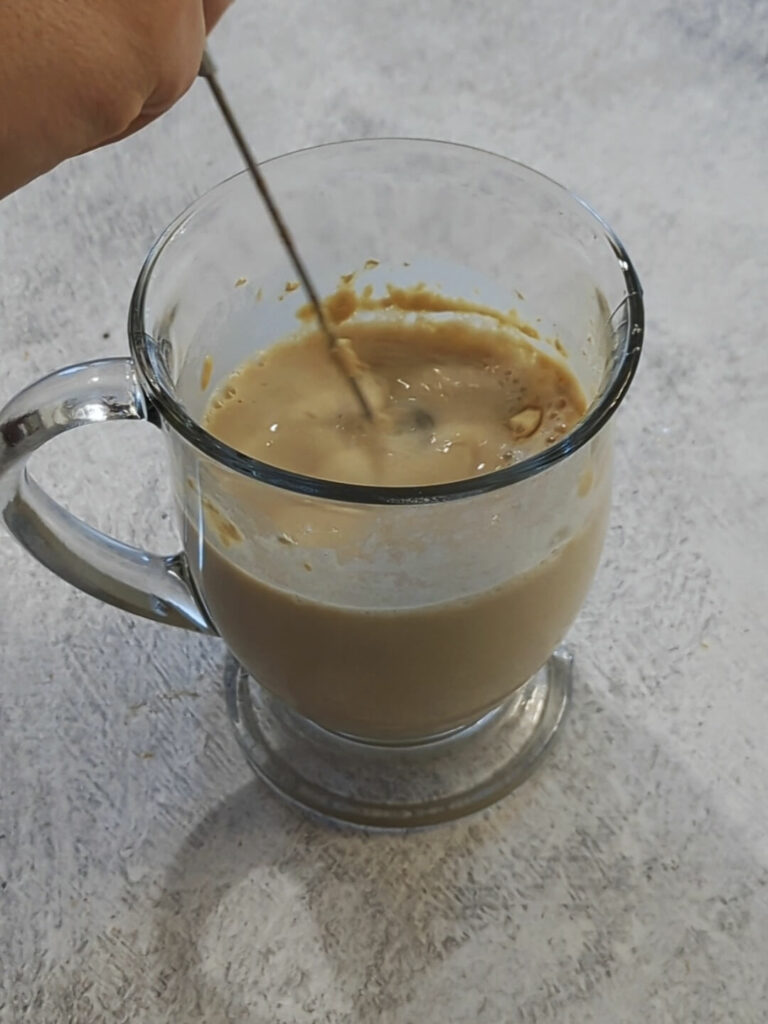 Almond milk and vanilla protein powder combined in a cup.