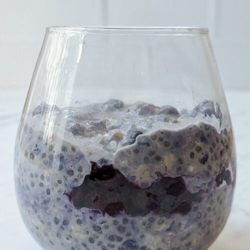 A side view of overnight oats with frozen fruit.