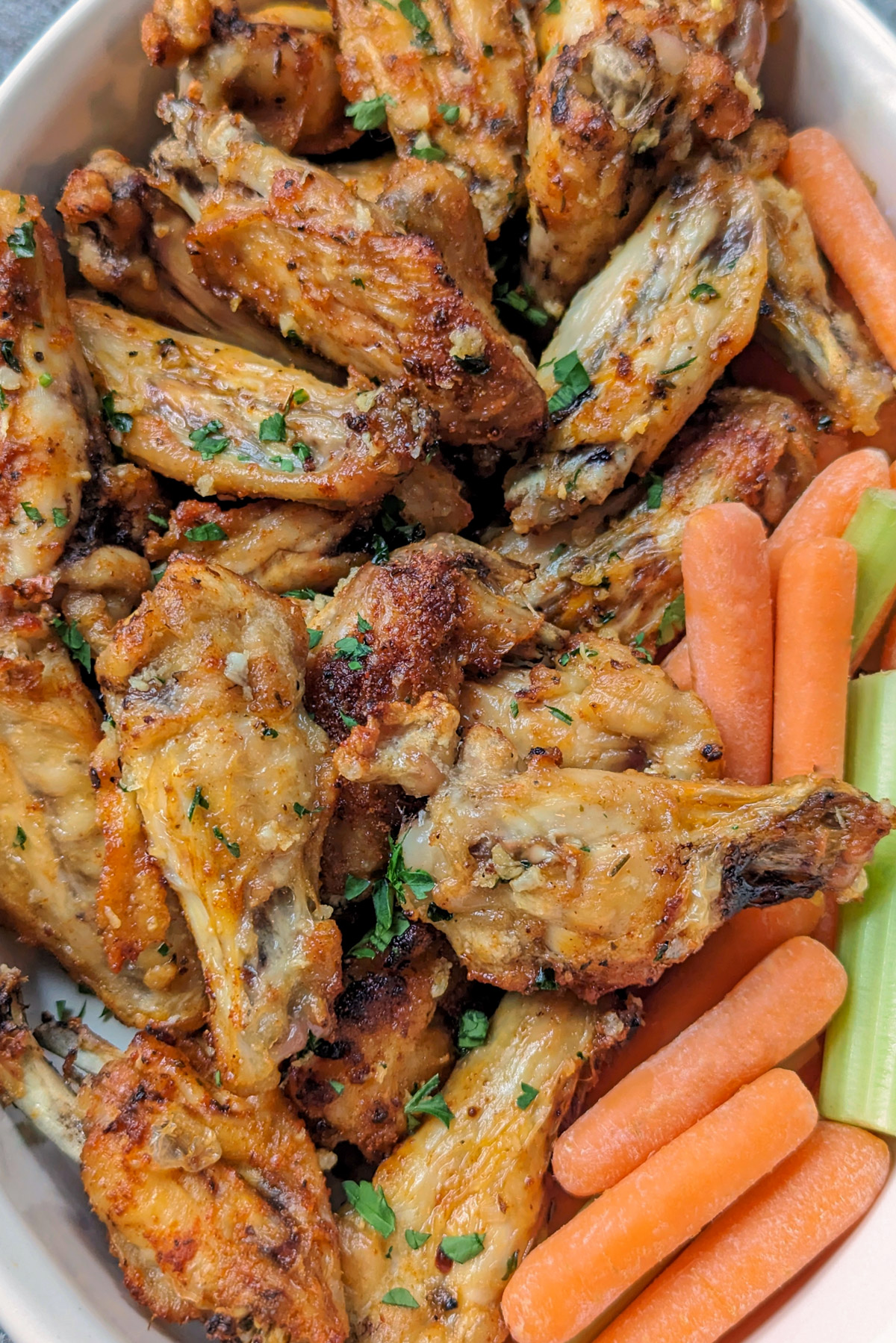 Garlic butter chicken wings in a serving dish. 