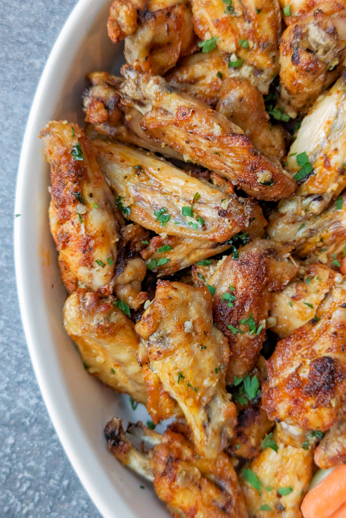 Garlic butter chicken wings in a serving dish.