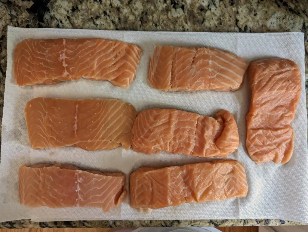 Salmon fillets laid out on a dry towel.