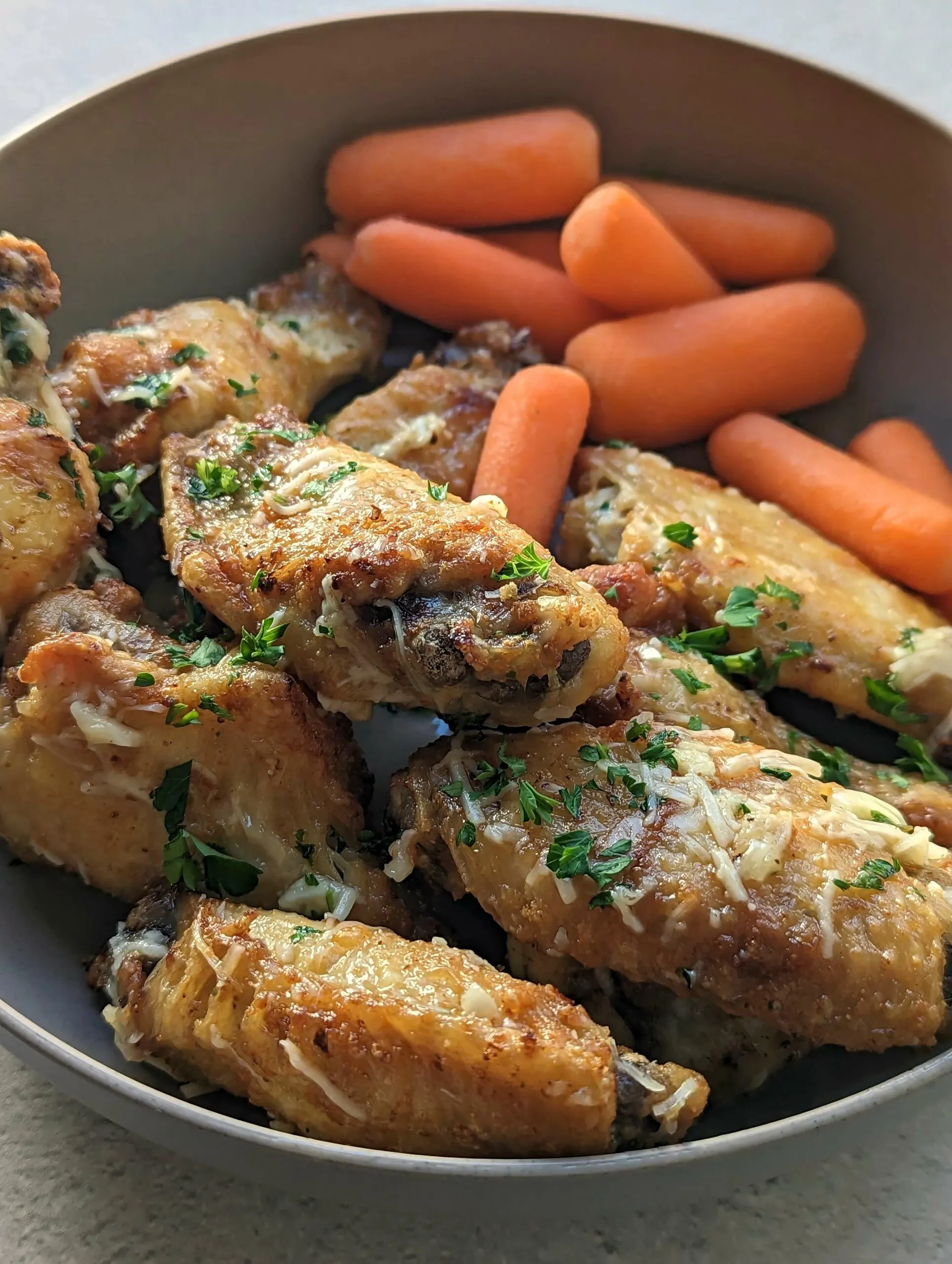 Air Fryer Garlic Parmesan Wings on a plate with carrots.