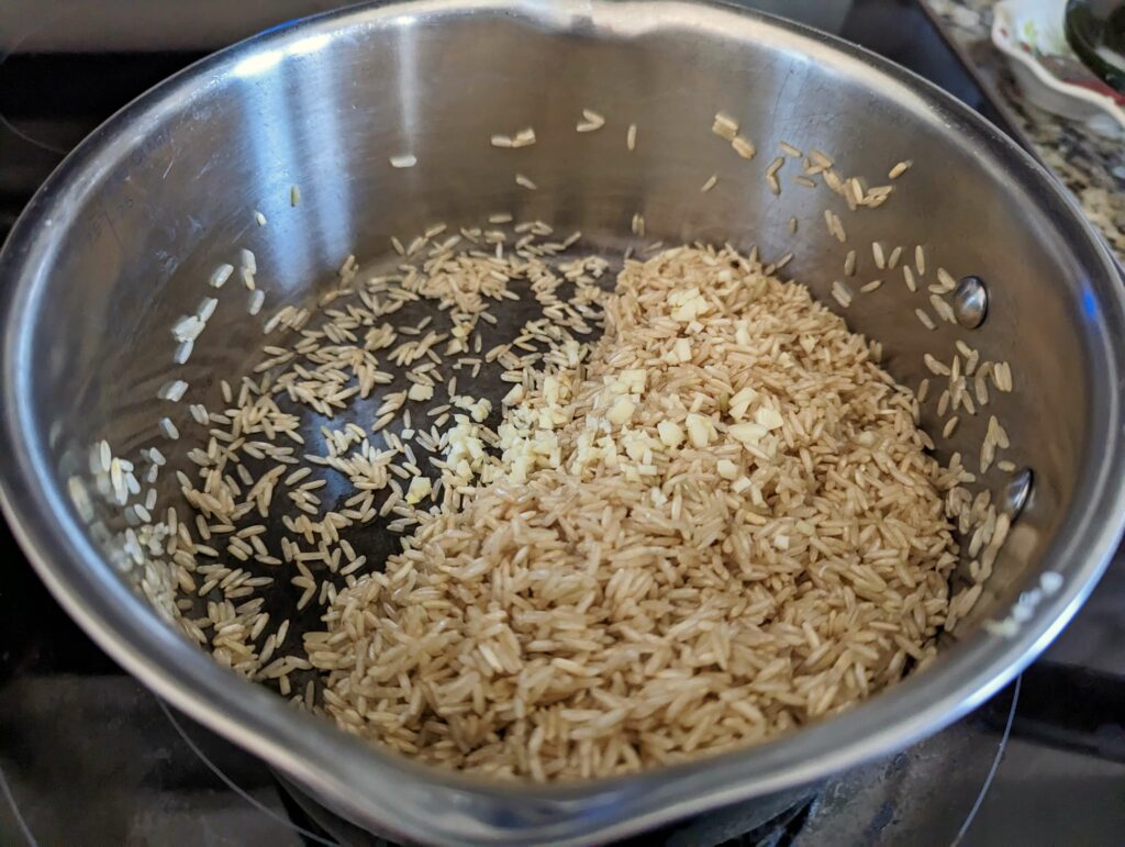 Rice and garlic toasting in a pan.