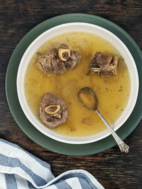 An overview of a bowl of Mutton Soup with a spoon in it.