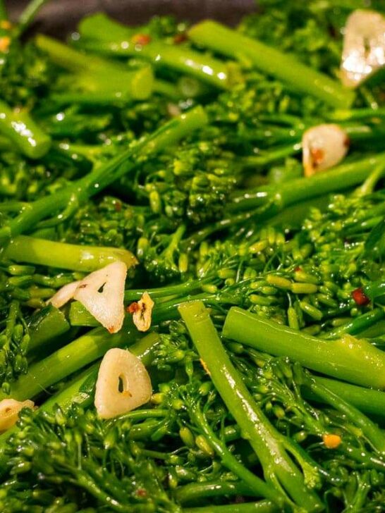 A close up of broccolini cooking in a pan.