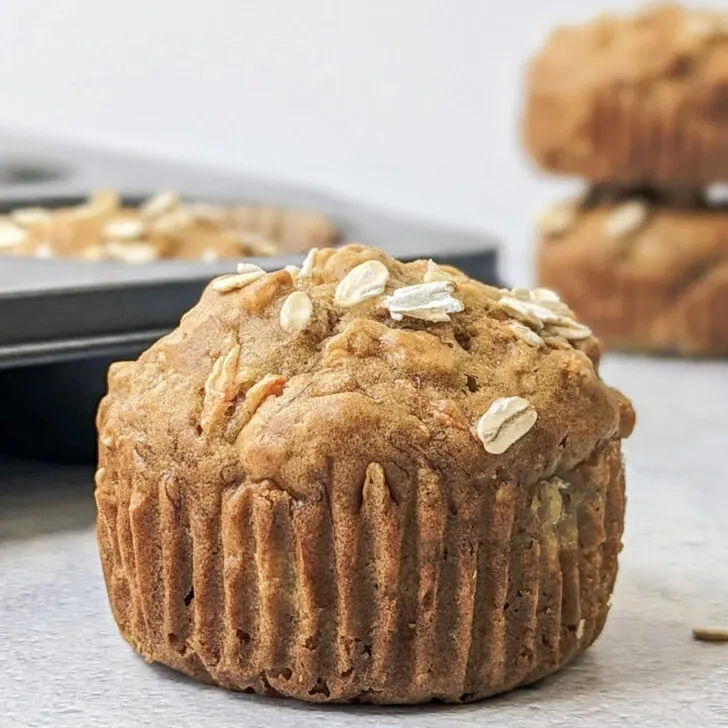 A close up of a banana carrot muffin with muffins in the background.
