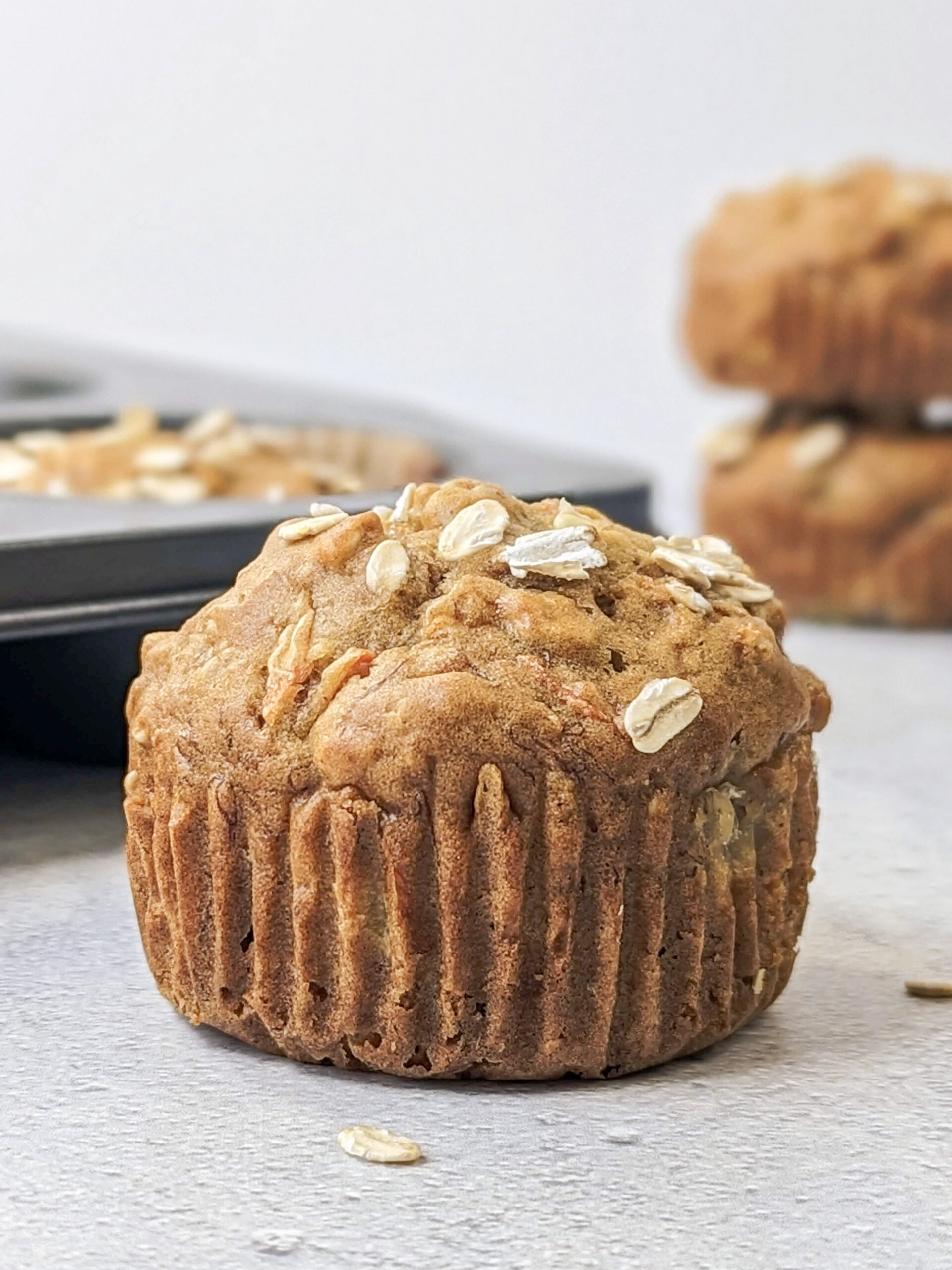 A close up of a banana carrot muffin with muffins in the background.