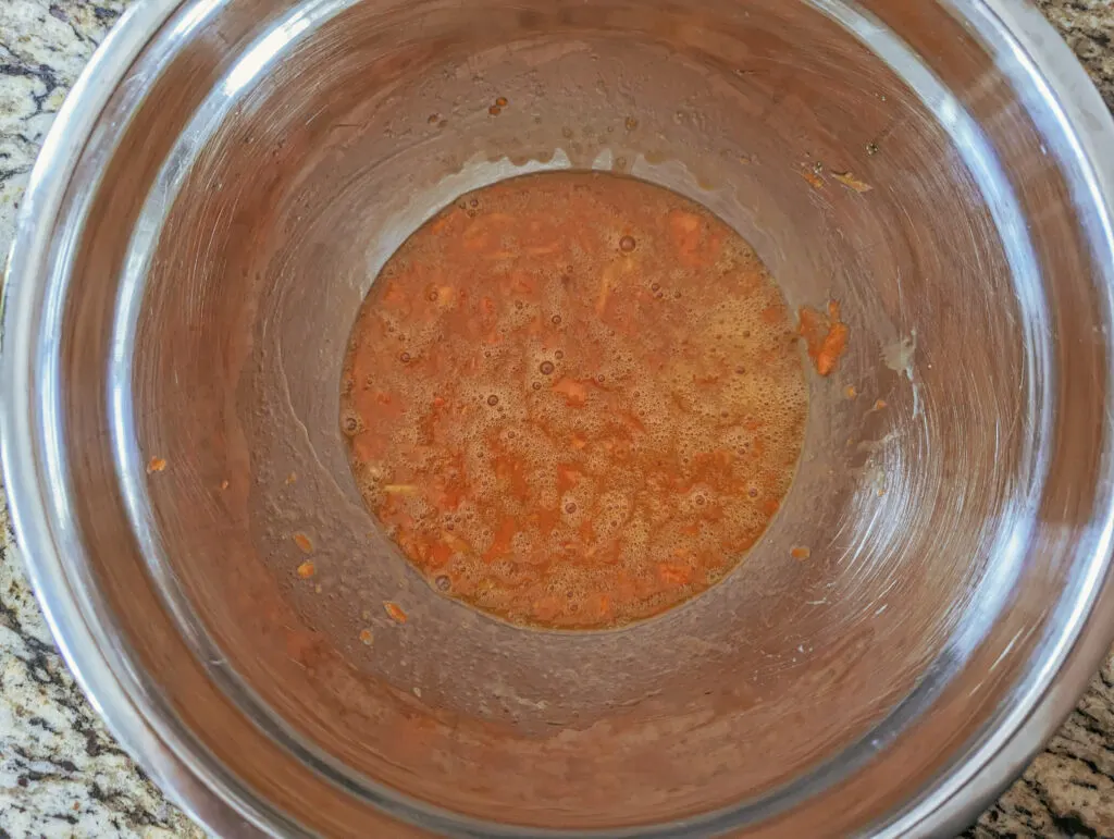 The wet ingredients for banana carrot muffins combined in a mixing bowl.