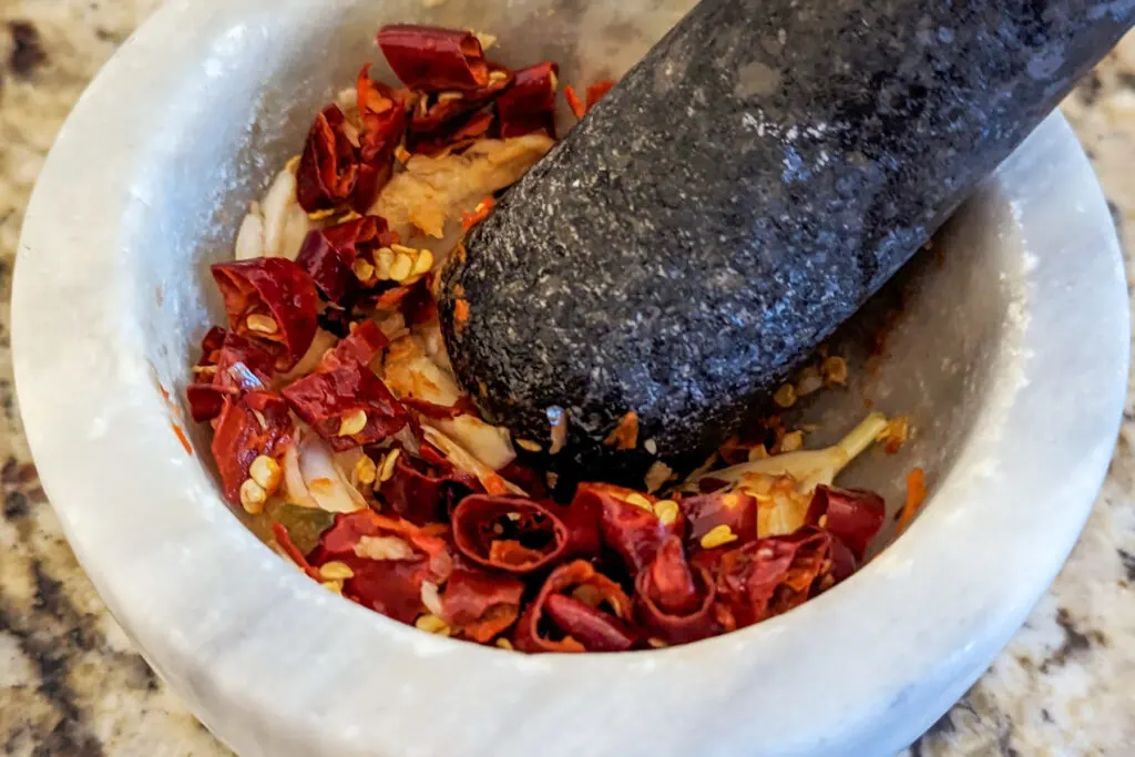 Chiles and garlic in a mortar and pestle.