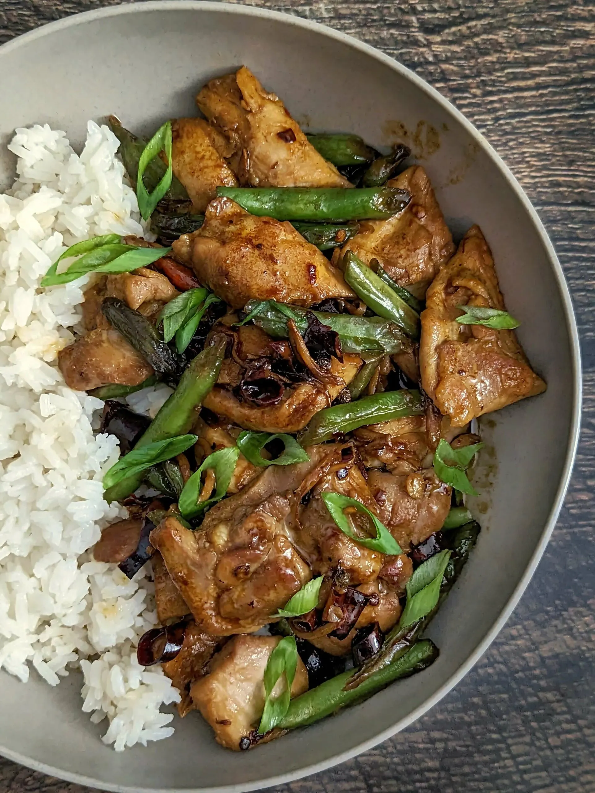 A plate of pad cha with chicken served with steamed white rice.