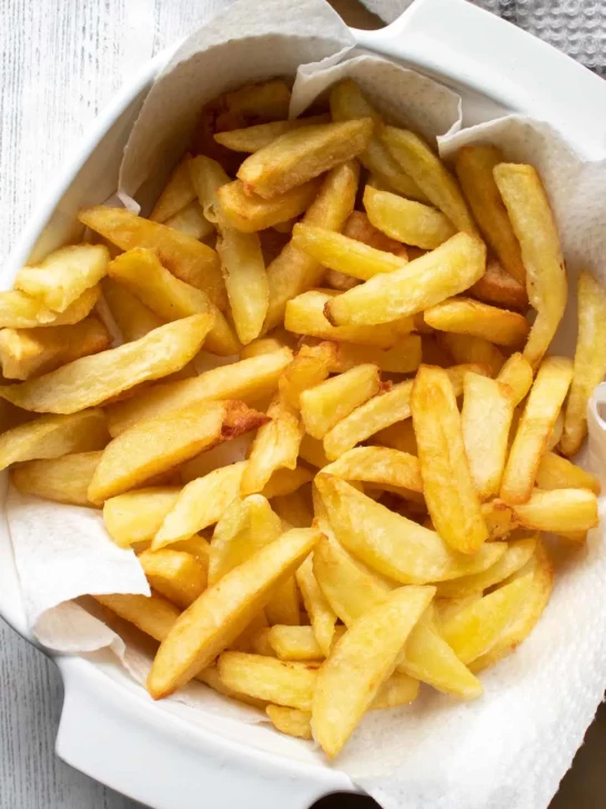 Large homemade french fries in a bowl.