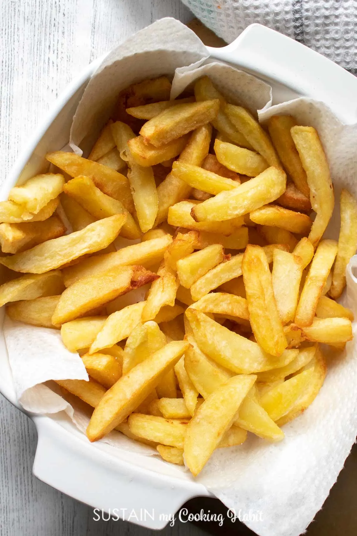 Large homemade french fries in a bowl.