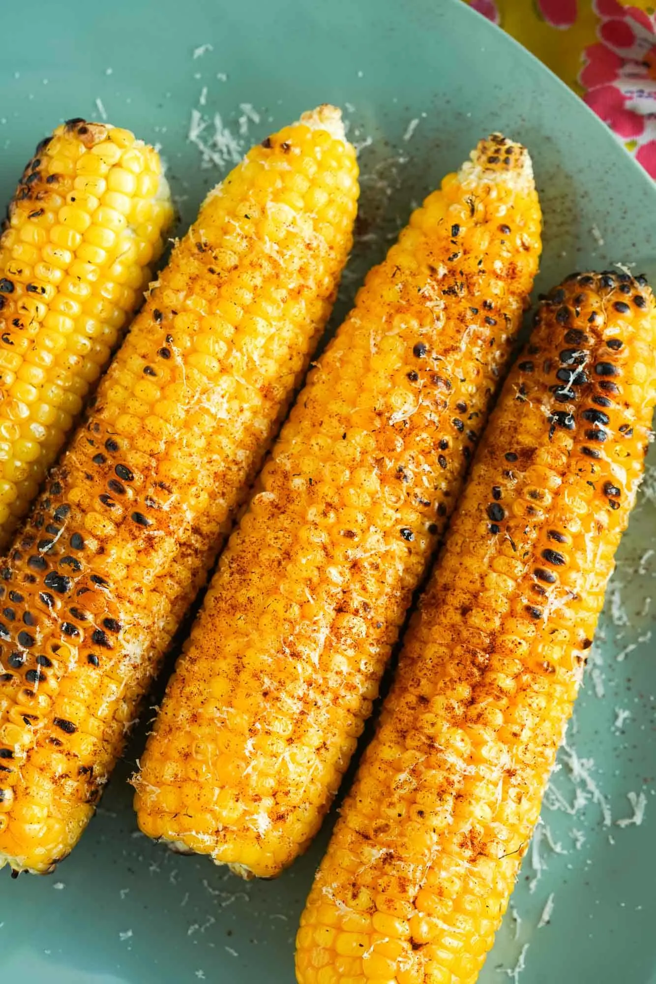 A close up of grilled corn on a plate.