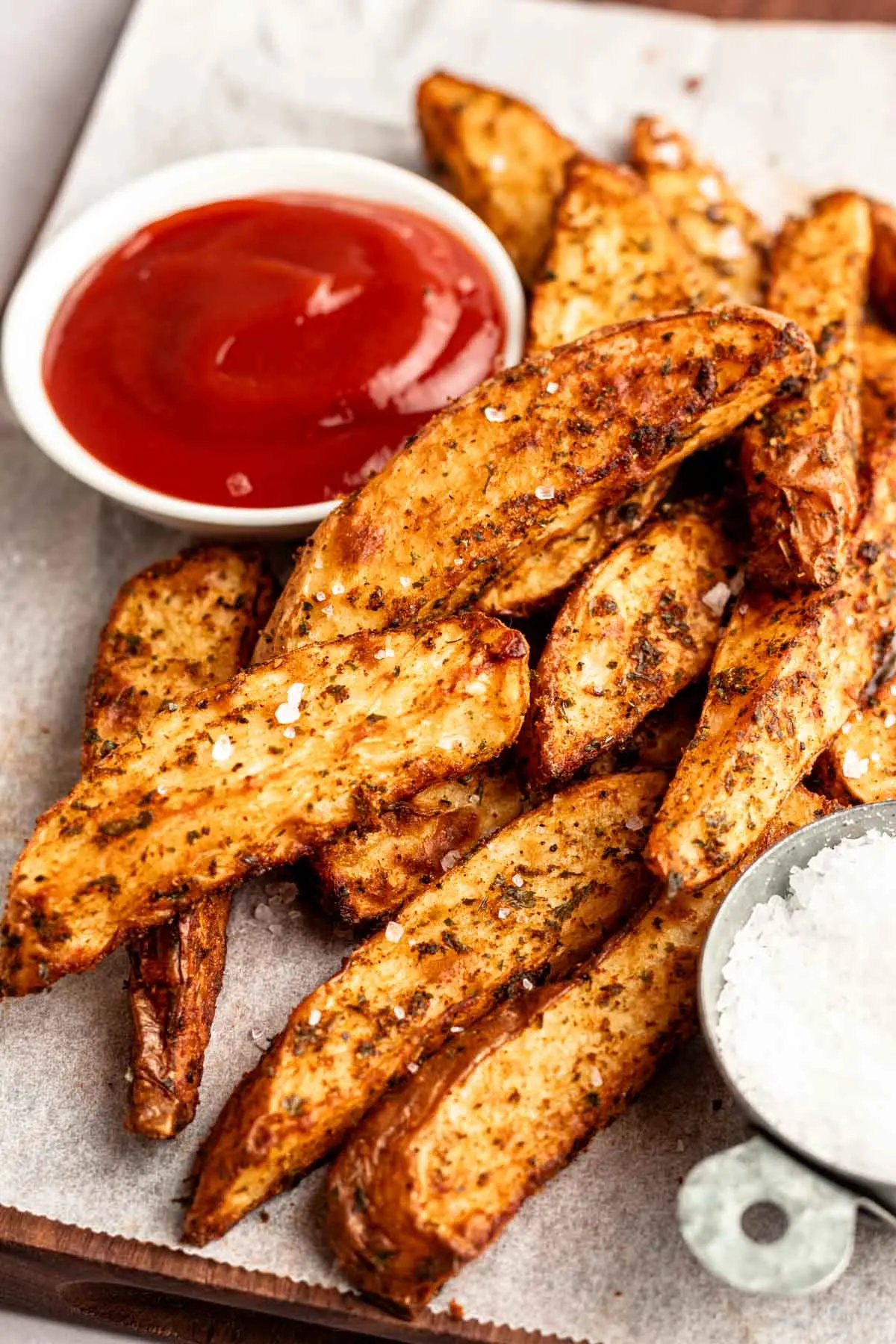 Potato wedges with ketchup and ranch.