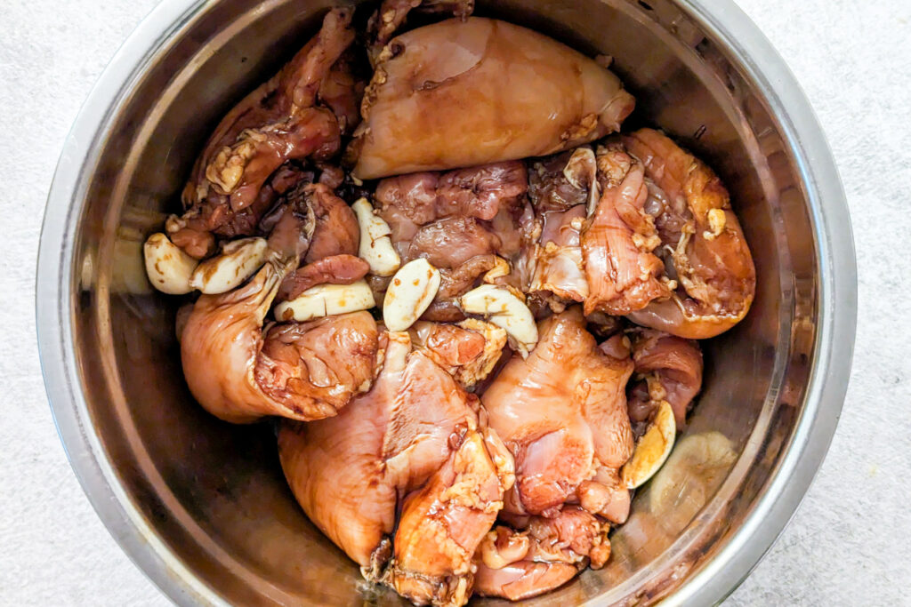 Chicken marinating in a mixing bowl.
