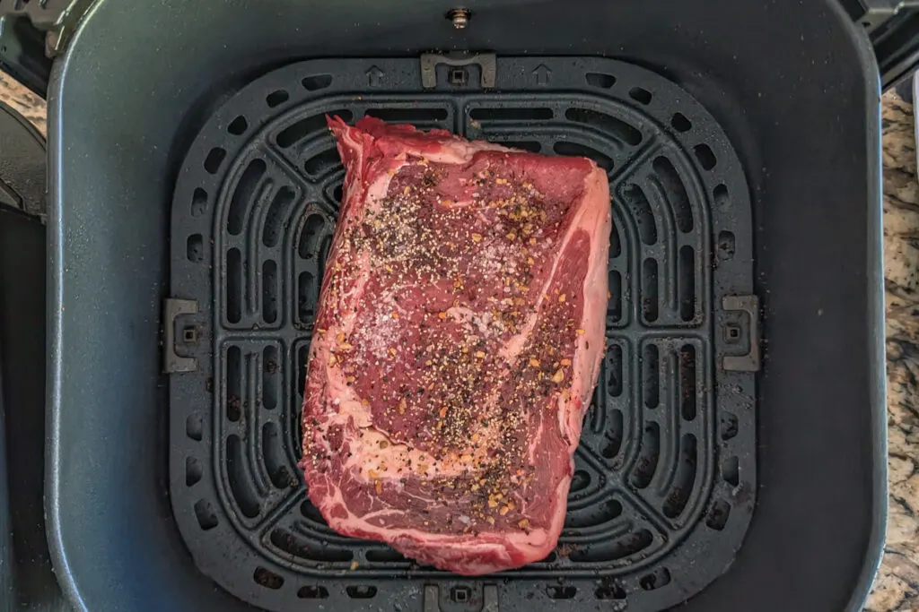 A ribeye steak cooking in the air fryer.