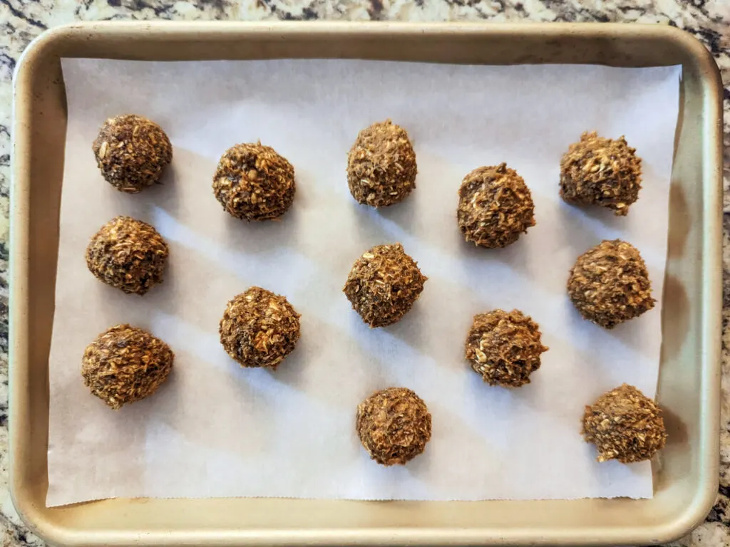 Protein balls rolled out onto a rimmed baking sheet.