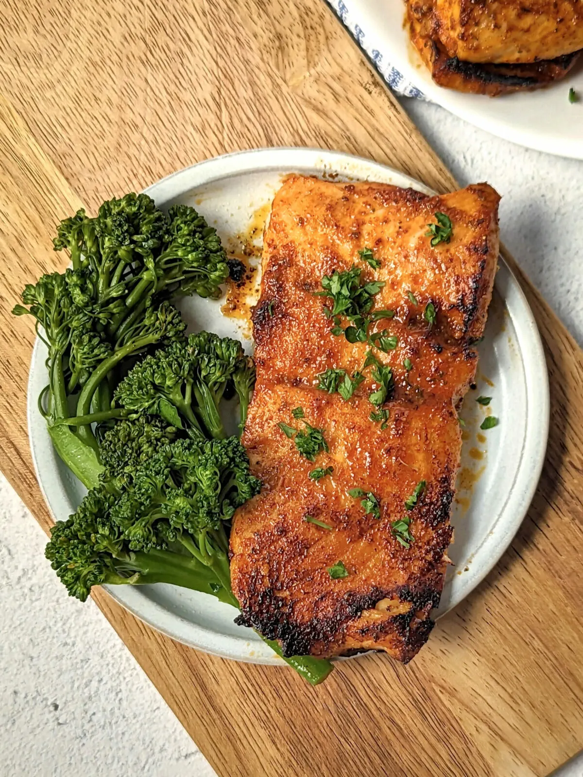 Cajun honey butter salmon on a plate with broccolini.