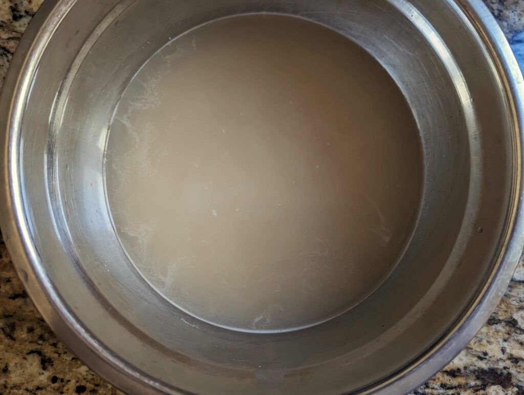 Basmati rice soaking in a bowl of water.