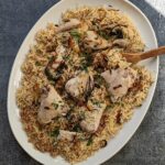 A large platter of Chicken Yakhni Pulao topped with chopped cilantro.