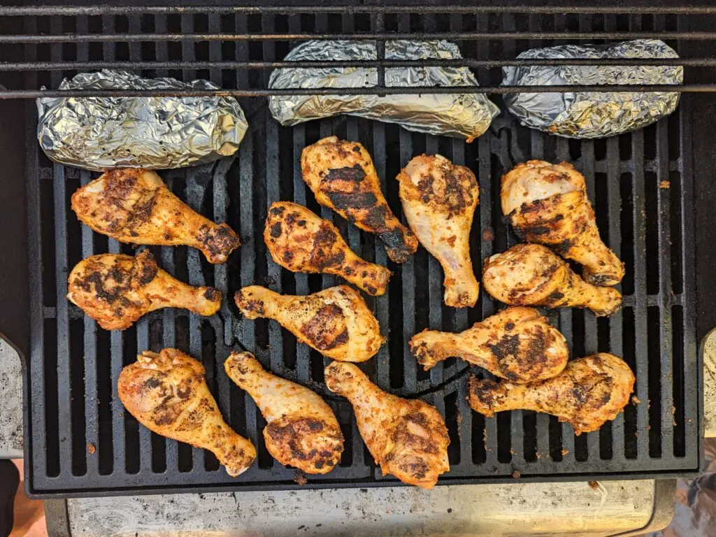 Drumsticks on the grill with a slight char.