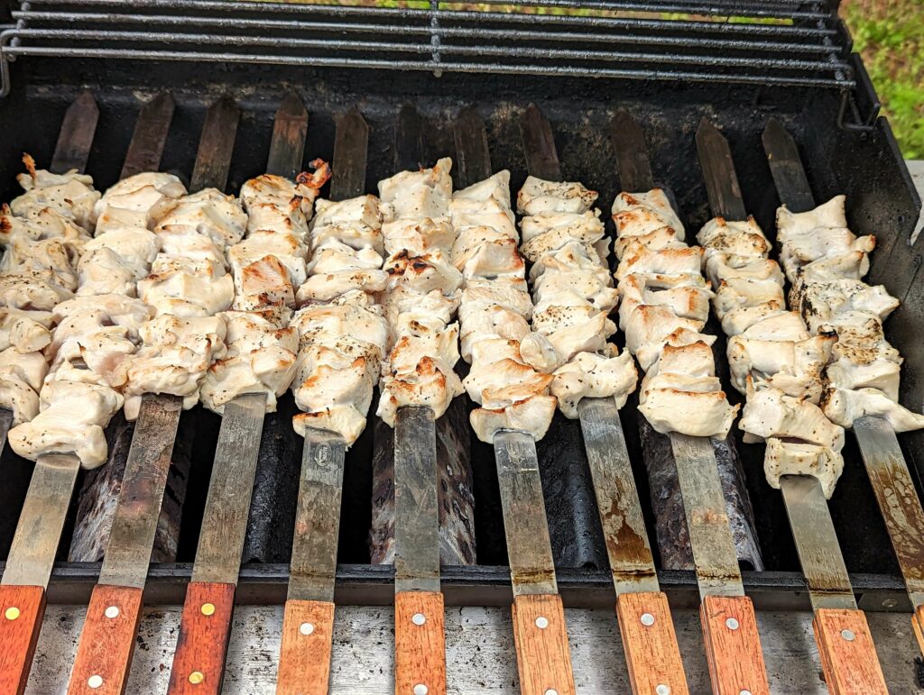 Joojeh kabobs flipped on the grill.