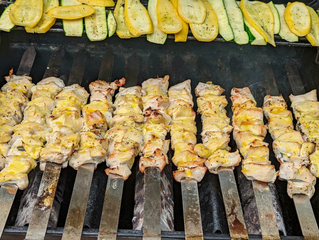 Joojeh kabobs coated in saffron butter on the grill.