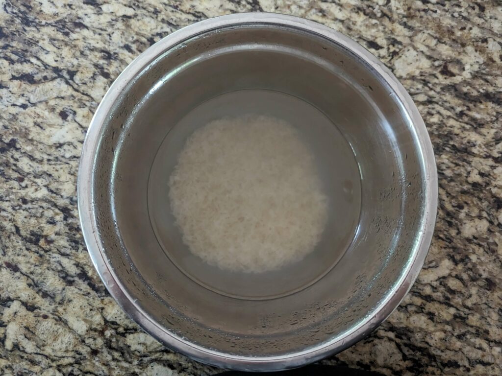 Rice soaking in a mixing bowl.