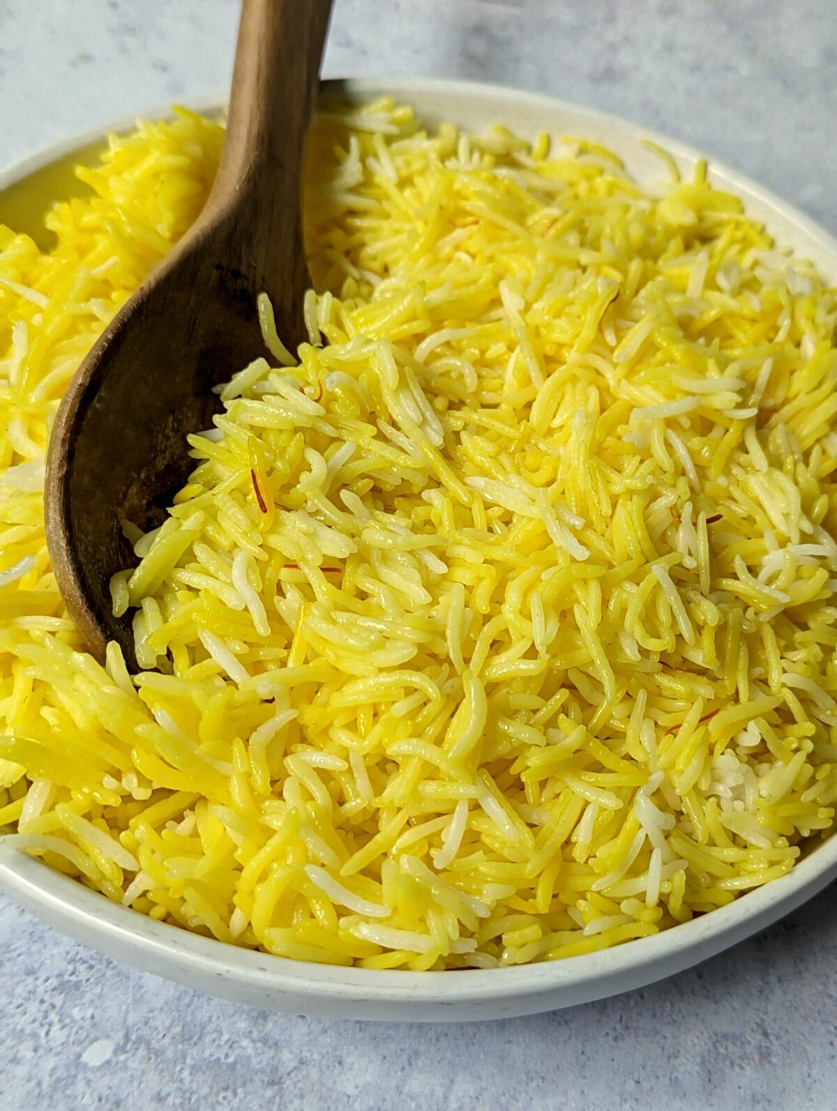 A close up of a serving bowl of saffron rice.